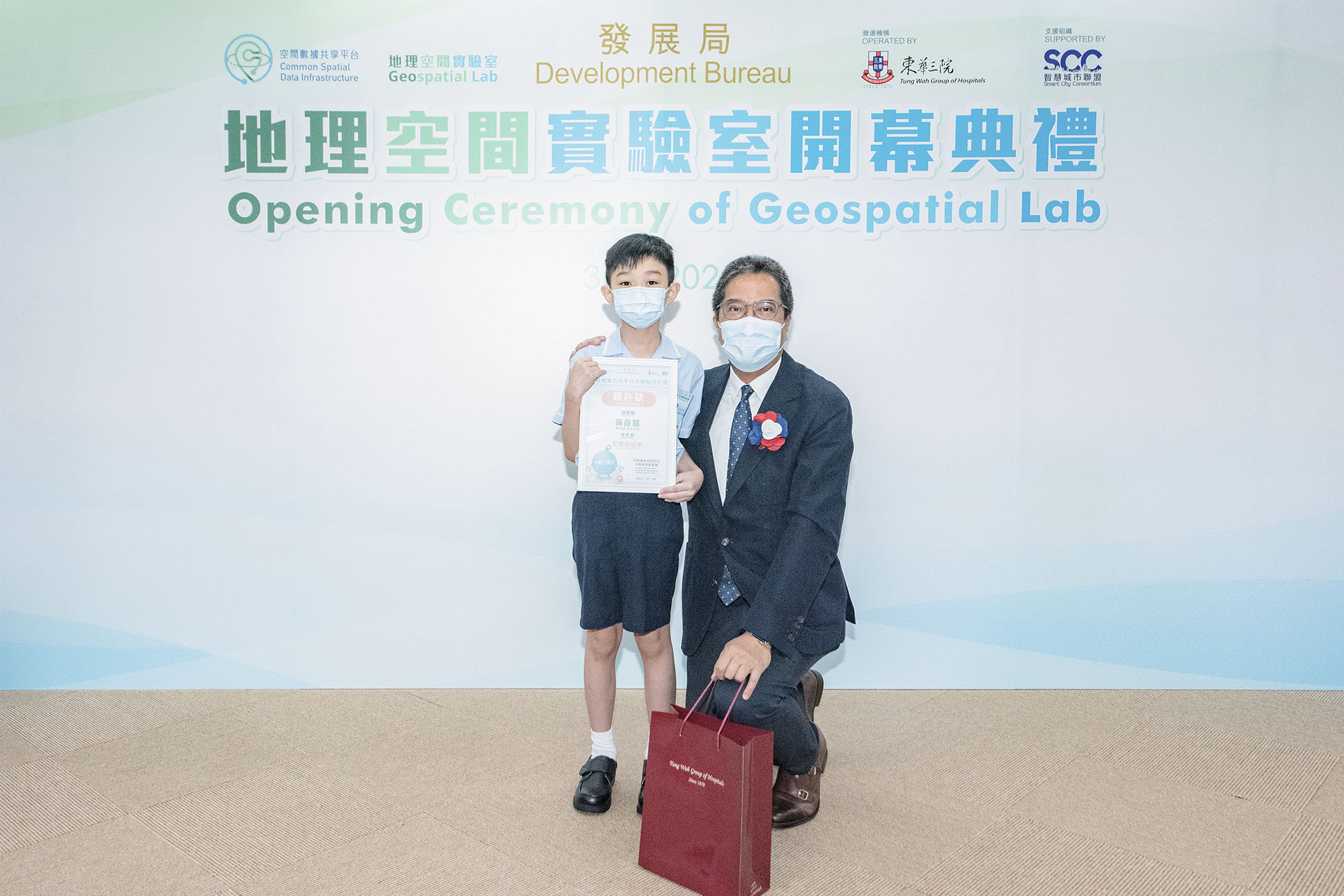 Mr. WONG Wai Lun, the Secretary for Development, took a photo with the Grand Champion Award winner Wong Yin Lok.